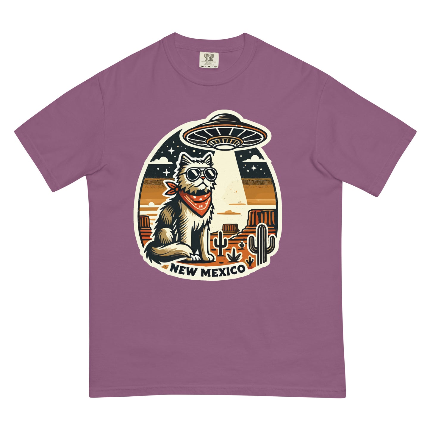 Purple New Mexico cat t-shirt featuring a cartoon cat with sunglasses and bandana under a UFO in desert landscape